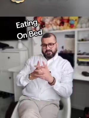 The cover image showcases a man with a beard and glasses in a seated pose, hands clasped in front of him. He is wearing a white shirt and light colored pants. The background appears to be a room with shelves and a large television.