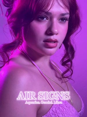 A close-up portrait of a person with a pinkish purple overlay. The person has dark hair in soft waves and side-swept bangs with pink highlights, the skin is fair, and lips are glossy with lip color, a delicate necklace is visible. The image is set against a blurred purple background and includes text overlay in bright neon.