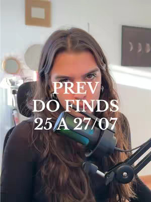 A woman with long brown hair is centered in the image, looking at the camera. Text overlays the image, with a microphone extending from the bottom center, and the background includes parts of a room with some decor.