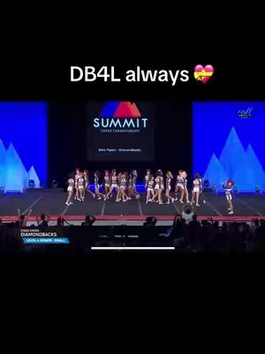 The cover image shows a live performance of a cheerleading/dance team on a stage. The team is wearing matching uniforms and performing in front of a large screen and a crowd. Text overlay at the top reads "DB4L always", and includes a heart emoji. The text is white with a black background and heart emoji is red and yellow. The stage is well-lit, and the composition focuses on all the team members in action with some spectators. The background is dark with blue-glowing lights.
