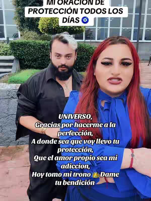 The cover image is a medium shot featuring two individuals: a man and a woman. The woman is on the right, wearing a blue outfit and her hair is a striking red. The man is on the left, sporting a black shirt and a beard with a streak of white hair. Overlaid text in a handwritten style is positioned above the woman's head, and the background features a blurry outdoor setting.