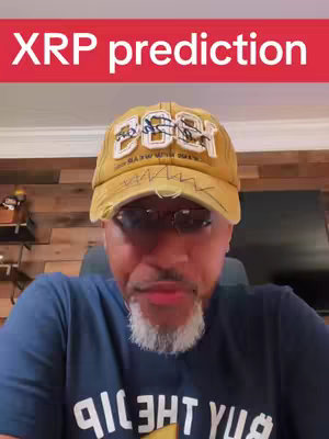 A man with a gray beard and glasses is the central figure of the image, wearing a blue shirt and a yellow cap with white text and a torn edge. The text "XRP prediction" is overlaid on a red background. The background shows a wooden wall detail.