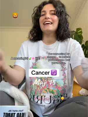 A woman with curly dark hair smiles, wearing a white t-shirt with an image of a floral print and the word "Cancer" over it. Text overlays include phrases about life and astrology symbols.
