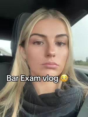 A close-up shot of a young woman with blonde hair in a car. The text 'Bar Exam vlog' is overlaid on the image.