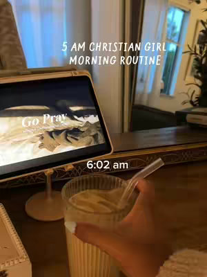 The cover image shows a cozy, warm morning scene. A tablet displaying the words 'Go Pray' is positioned prominently, likely playing a video. Below, a hand holding a glass of creamy beverage with a straw. The lighting suggests early morning, with a glimpse of a window in the background.