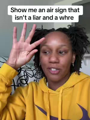 A woman with dark locs wearing a yellow hoodie, gesturing with her hand. Text overlay says 'Show me an air sign that isn't a liar and a whre'.