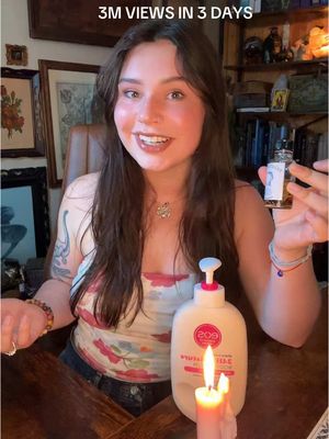 The cover image features a woman with long brown hair, smiling at the camera while holding a small bottle, a bottle of lotion, and a lit candle. The background is a room with wood paneling and framed pictures. Text overlay at the top says "3M VIEWS IN 3 DAYS."