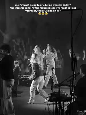 A black and white image captures a live worship performance. Two women with long blonde hair are center stage, singing into microphones, with other musicians and a crowd partially visible in the background. The lighting is focused and the image is slightly grainy.