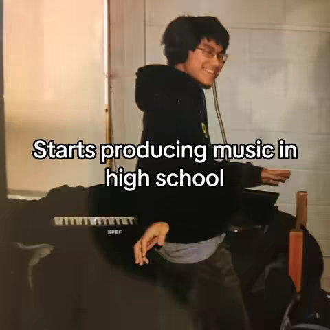 A slightly desaturated photo of a young man in a black hoodie, standing near a piano, with text overlayed.