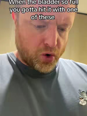 The cover image features a close-up of a man's face, who is looking down with a slightly strained expression. The text overlayed on the image says, "When the bladder so full you gotta hit it with one of these". The man has a reddish beard and is wearing a grey t-shirt with some design on it.