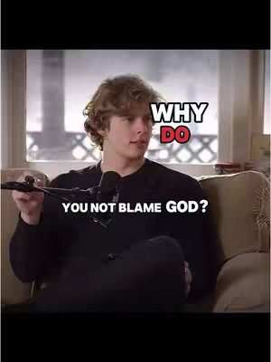 A young man sits on a couch holding a microphone, with text overlays that ask, "Why do you not blame God?"