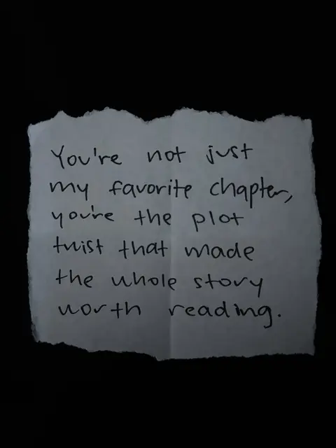 A torn piece of paper with the text 'You're not just my favorite chapter, you're the plot twist that made the whole story worth reading.' written on it in handwritten style. The background is solid black.