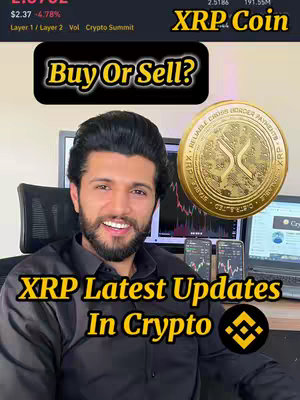 A man with a beard smiles, positioned in front of computer monitors, three smartphones displaying crypto charts, and an XRP coin graphic. Text overlays include 'Buy Or Sell?' and 'XRP Latest Updates In Crypto'. A Binance logo is also visible.