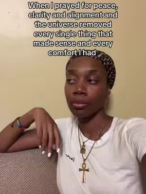 The cover image shows an eye-level shot of a Black woman. She has short hair and is wearing a patterned headscarf and a white t-shirt. She has a serious expression and looks slightly off-camera. She has on a necklace with a cross pendant. Text is overlaid at the top.