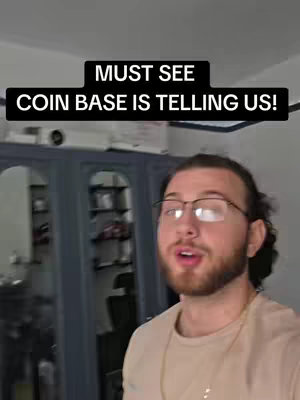 The cover image features a man with glasses in the foreground, looking directly at the camera with an open mouth. Above him is a black banner with white text that reads: "MUST SEE COIN BASE IS TELLING US!" The background is a blurred interior scene with a dark-colored cabinet and a glimpse of other items.
