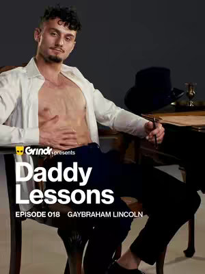 A man with a half-unbuttoned white shirt sits in an ornate wooden chair. The backdrop is a dark gray, and on a table beside him, there’s a hat, writing implements, and papers. Text overlays near the bottom of the image read “Grindr presents,” followed by “Daddy Lessons” in bold white font, and lower down, “EPISODE 018 GAYBRAHAM LINCOLN”.
