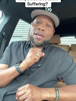 A man wearing a baseball cap and a dark shirt is speaking from inside a car. The framing focuses on his upper body and head as he gestures with his right hand. Text at the top of the frame asks a question.