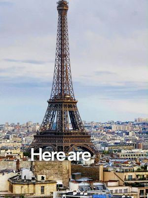 The cover image features the Eiffel Tower prominently centered against a backdrop of a cityscape with buildings densely packed. The sky is overcast, suggesting a daytime shot under a light cloud cover. The text “Here are“ is superimposed on the foreground, near the base of the tower, providing introductory context.