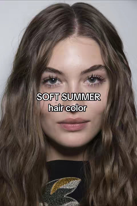 A close-up shot of a woman's face with wavy brown hair. The text overlay says "SOFT SUMMER hair color". The woman has pale skin, blue eyes, and pink lips. She is wearing a black top.