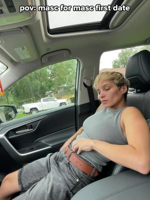 The cover photo shows a person in a car, the POV is a masc for masc first date. They are wearing a grey shirt and shorts with a brown belt.  The car's sunroof is open, and a white truck is visible in the background through the car window.