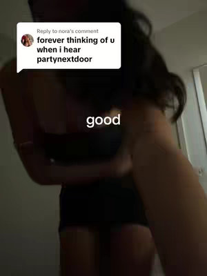 A dimly lit, slightly out-of-focus image of a person, seemingly a woman from the hair, in a dark top, likely a dress or similar garment, her arm and torso are visible and are the focus of the imagery, complemented by a comment overlay with text on the top left corner. The background is nondescript, with a door frame or similar structure on the right.