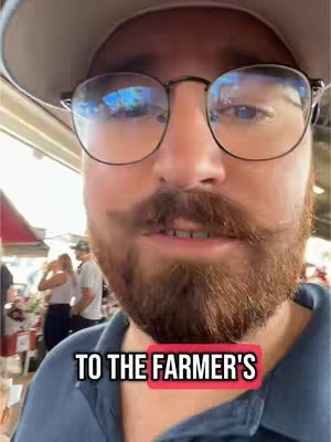 A close-up shot of a man with a beard, mustache, and glasses is centered in the frame, with text overlaid at the bottom. The man is looking towards the camera and appears to be speaking. The background is slightly blurred.