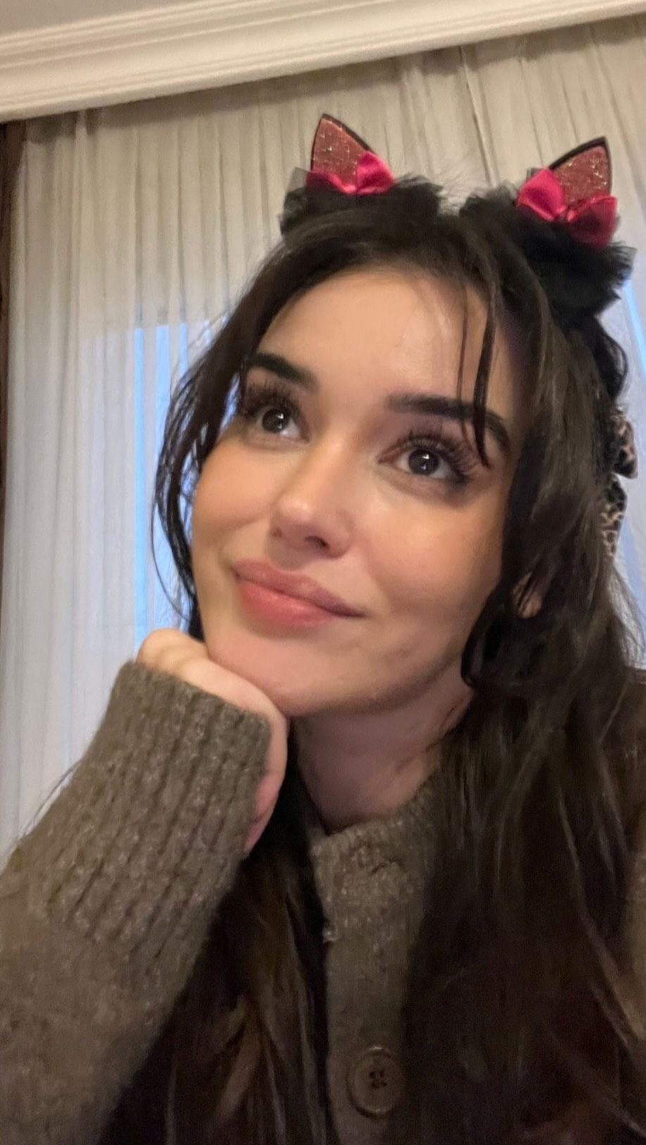 The cover image shows a young woman with long dark hair, wearing a brown sweater. She has a cat ear headband on. She is looking up and to the right with a slight smile. Her hand is on her chin.