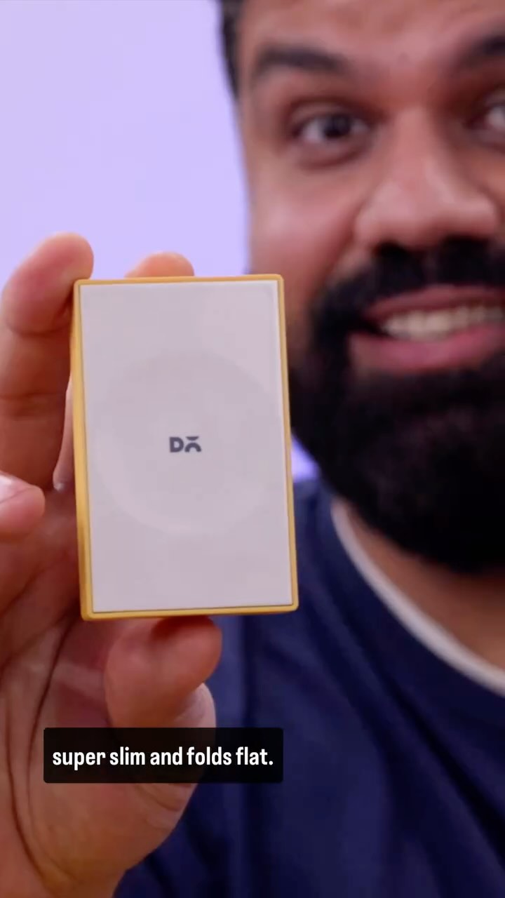 A man with a beard holds a white and gold rectangular device. Text overlay on the image says "super slim and folds flat."
