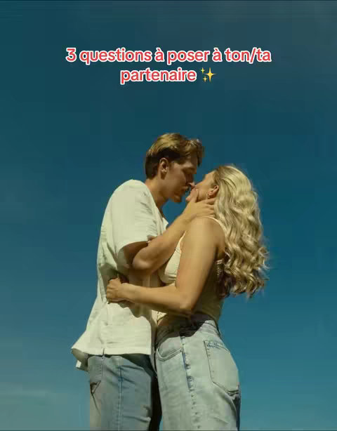 A couple kissing against a clear blue sky. The man, with short blond hair, is wearing a white t-shirt and jeans. The woman, with long blonde hair, is wearing a cream top and jeans. Text overlayed at the top reads "3 questions to ask your partner."