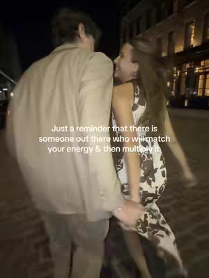 A couple is captured in the night, close together with a woman in a dress in the right of the frame. Text overlaid on the image reads "Just a reminder that there is someone out there who will match your energy & then multiply it".