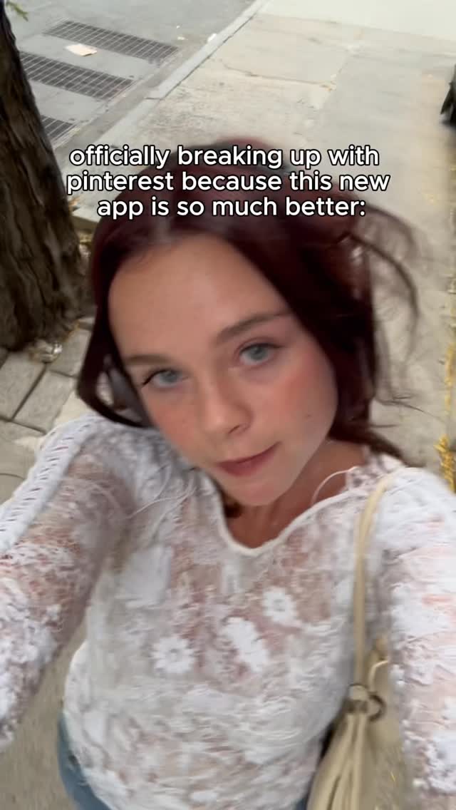 A young woman wearing a white lace top is taking a selfie. The background is a blurry street scene with a concrete sidewalk and a tree on the left side. Text overlay is put right above the woman’s head, where she’s showing a serious expression.