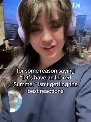 A selfie-style shot featuring a young woman with long dark hair and bangs, wearing headphones. She is positioned from the chest up, with the background showing a room with a television and other items. Text overlays the lower portion of the image.