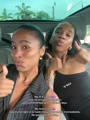 Two young women inside a car, taking selfies together with thumbs up gesture. The woman on the left side holds out her thumb in a thumbs-up gesture, wearing a striped top.  Beside her, another woman gives a thumbs up with a black top. Text overlay at the bottom provides context: one woman admits to letting a tire pressure light go unaddressed, while her friend the Aries friend immediately took action.