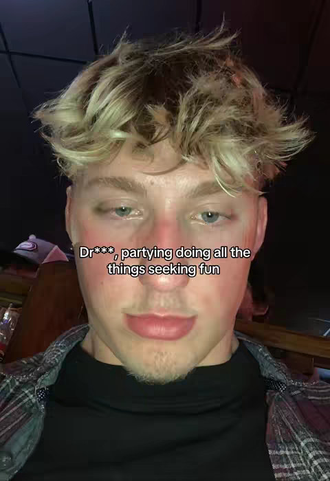 A selfie-style image features a fair-skinned person with blonde, tousled hair in a dark setting. The person appears to be smiling slightly. The text is partially obscured by a censored word. The person is wearing a casual plaid shirt and a black tee. The background is dark. The overall composition suggests a relaxed, candid feel.