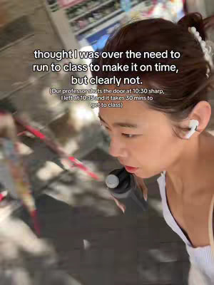 A selfie-style video cover image. A person is running with a water bottle in their hand. Text is overlaid with a caption. The person is wearing earbuds, and the background has details of walls and buildings. The image is dominated by neutral colours and a soft focus.