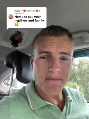 A man is shown from the chest up, looking directly at the camera. He has short, light-brown hair and is wearing a light-green collared shirt. He is seated in what appears to be a car, and there's a comment box overlayed on the upper left corner.