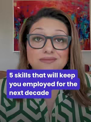 A woman with glasses is centered in the frame, set in front of an out-of-focus backdrop featuring a framed artwork, likely a painting. She has brown hair, and wears black square glasses. On the lower portion of the screen is a purple box with white text overlay describing 5 important skills for the job market.