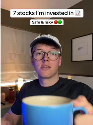 A man wearing glasses and a white baseball cap is holding a blue mug, likely preparing for or in the middle of a conversation or presentation. Above him is an overlayed title with the text "7 stocks I'm invested in", the video highlights the content to follow.