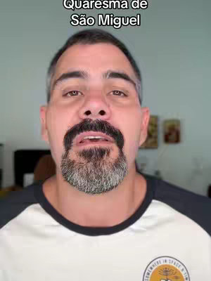 The cover image is a selfie of a man from the chest up. The man has short, dark hair with some graying, a full beard, and a graying mustache. He directly looks at the camera with a neutral expression. Above his head is the text: "Quaresma de São Miguel". The background is light and somewhat blurred. He wears a white t-shirt with black sleeves and a small logo on the chest.