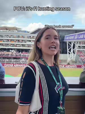 A woman is facing the camera with an open mouth. Above her, the text "POV: it's f1 hunting season". In the background is a race track.