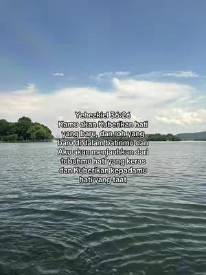 A scenic view of a lake and sky with text overlayed. The sky is a light blue with some clouds. The text is in white and is in Indonesian. The water is a slightly darker blue and the banks of the lake are covered in lush green trees.