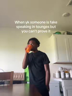 A young Black man is shown in a room, holding an orange cup to his mouth as if drinking, positioned in front of a table and a kitchen area. Above, overlaid text in white font reads, 'When yk someone is fake speaking in tongues but you can't prove it'.