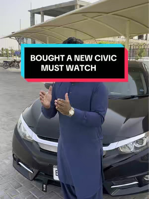 A man stands in front of a black car, with the hood and headlights in view. He is wearing a dark blue outfit and making a hand gesture. A text overlay in a rectangular shape reads "BOUGHT A NEW CIVIC MUST WATCH."