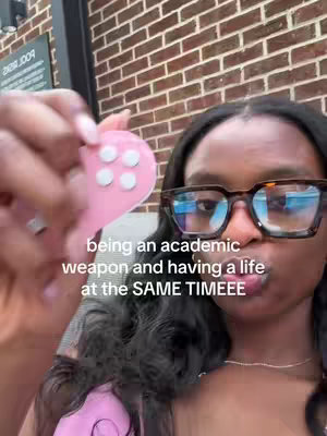 A person with glasses holding a heart-shaped object with buttons. They are in front of a brick wall. Text overlays the image.
