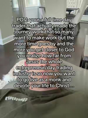 A selfie-style video cover showing a man in an olive green shirt looking down, with overlay text describing a day trader's journey and spiritual reflection. The background is blurred, suggesting an indoor setting.