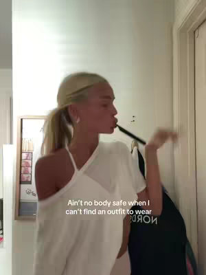 A young woman is captured in a selfie-style shot within a home setting. She is positioned slightly off-center, with a light-colored wall and a partially visible door frame serving as the backdrop. The woman is wearing a white top and appears to be puckering her lips, as if about to blow a kiss. The text overlay is positioned in the lower center part of the image.