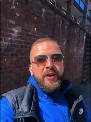 The cover image is a selfie of a man with a beard, wearing sunglasses and a blue hoodie. He is standing in front of a brick wall. The background includes more of the brick wall and a building.