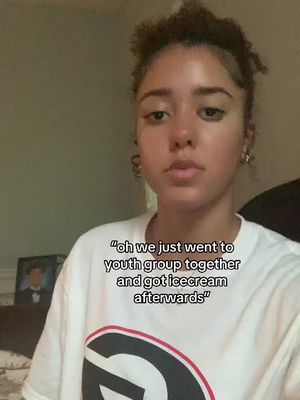 A young woman with curly hair and a white t-shirt is facing the camera with a neutral expression. Text overlay is added at the bottom of the image in a white box.