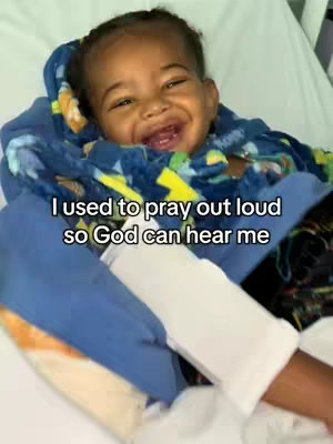 A close-up image of a smiling baby lying in a hospital bed, wrapped in a blue and patterned blanket. The baby is the focus, with text overlaid on the image.