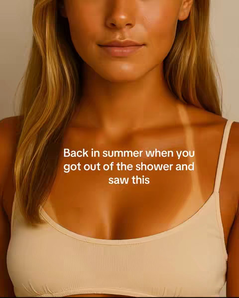 The cover image shows a close-up of a woman's upper body, showcasing tanned skin with visible tan lines from a swimsuit top. She is wearing a cream-colored top, and her blonde hair partially frames her face. The text overlay states, "Back in summer when you got out of the shower and saw this". The colors are warm, with a focus on the skin tones and simple background.